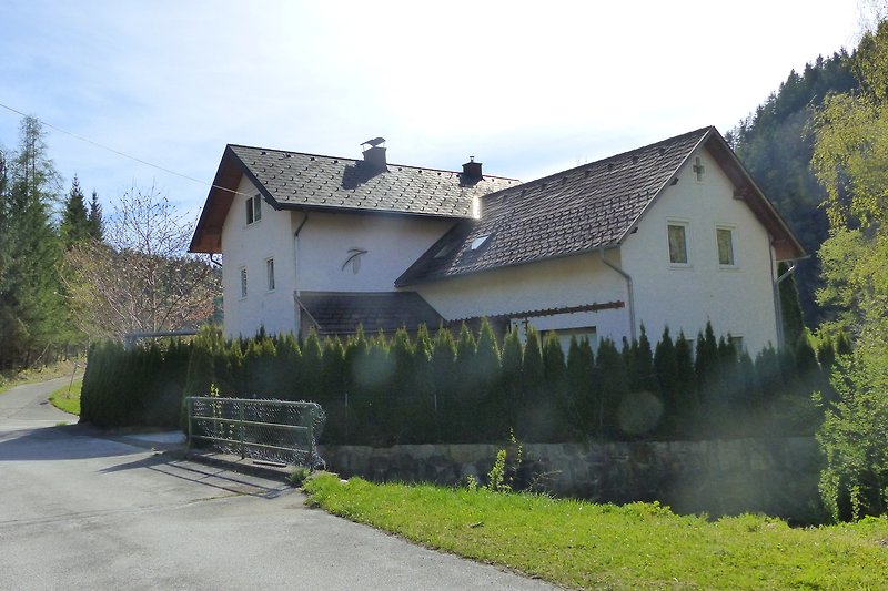 Ländliches Haus mit Bergblick und blauem Himmel.
