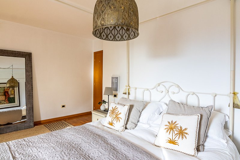 Stylish bedroom with comfortable bedding and elegant lighting.