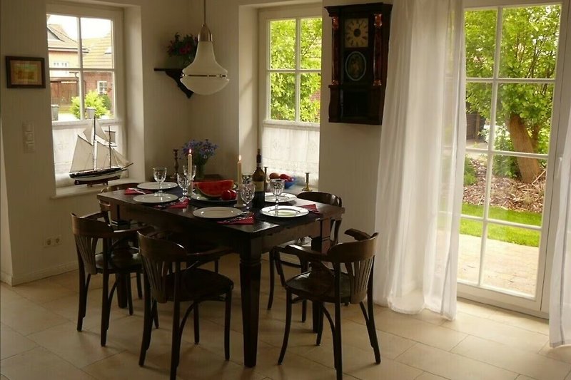 Küche mit Tisch, Stühlen, Fenster und Holzdetails.
