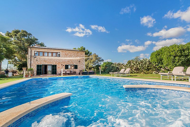 Luxuriöses Anwesen mit Pool, Garten und Sonnenliegen.
