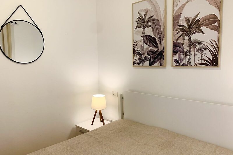 Modernes Schlafzimmer mit stilvollem Bett und dekorativer Beleuchtung.