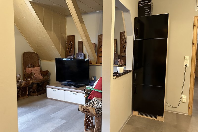 Stilvolles Wohnzimmer mit Holzmöbeln und Fernseher.