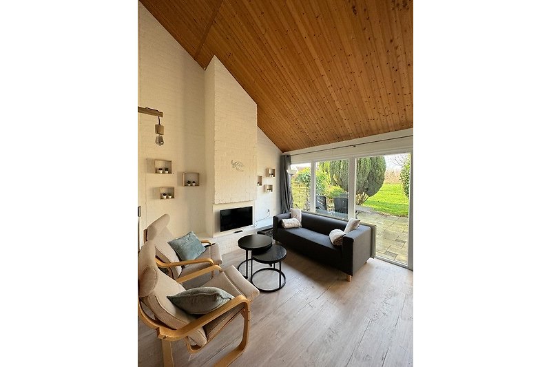 Wohnzimmer mit Holzmöbeln, Pflanzen und Fenster. Gemütliche Atmosphäre.