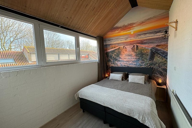 Schlafzimmer mit Holzbett, Kissen und Decke. Gemütliche Atmosphäre.