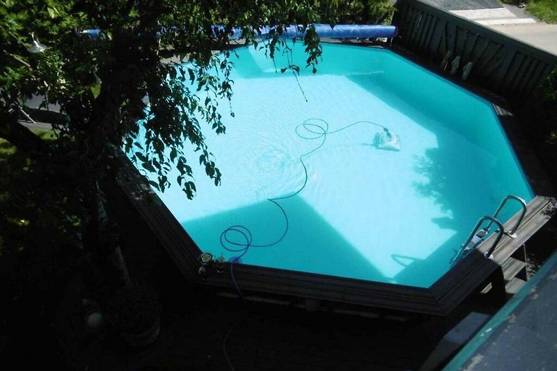 Luxuriöser Pool mit Gartenmöbeln und Auto.