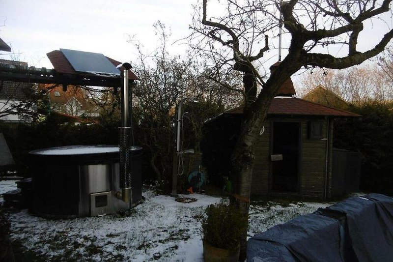 Winterlandschaft mit Cottage, Schnee, Frost und Garten.