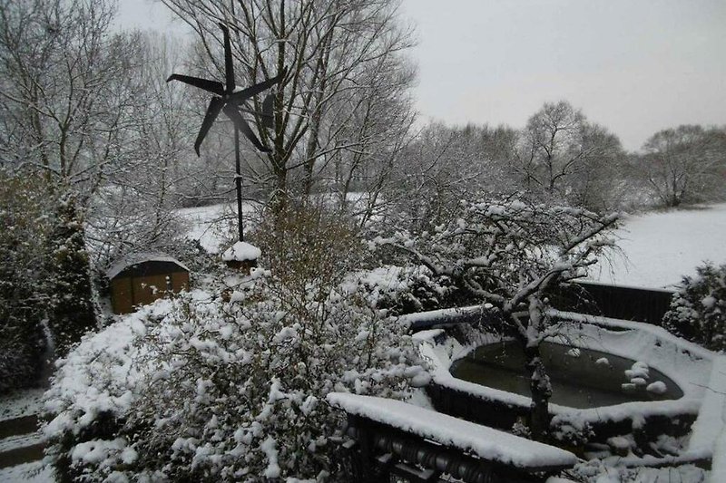 Winterlandschaft mit Haus, Schnee und Natur.