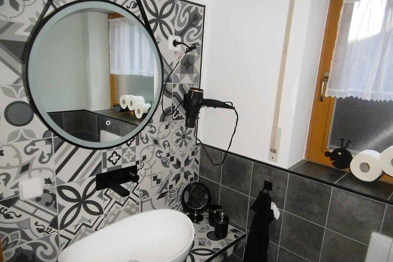 Modernes Badezimmer mit stilvoller Einrichtung und Keramikdetails.