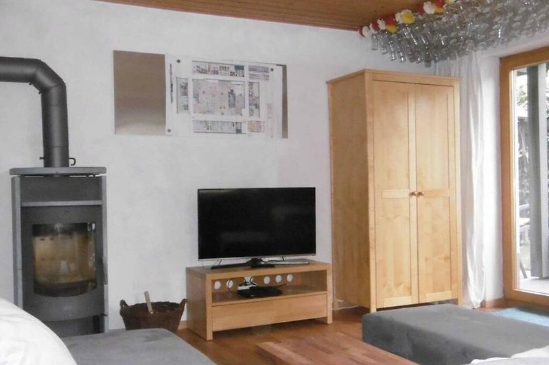 Wohnzimmer mit bequemer Couch, Fernseher und Holzmöbeln.