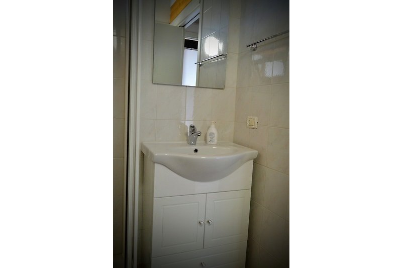 Elegante Badezimmerausstattung mit Spiegel und Waschbecken.