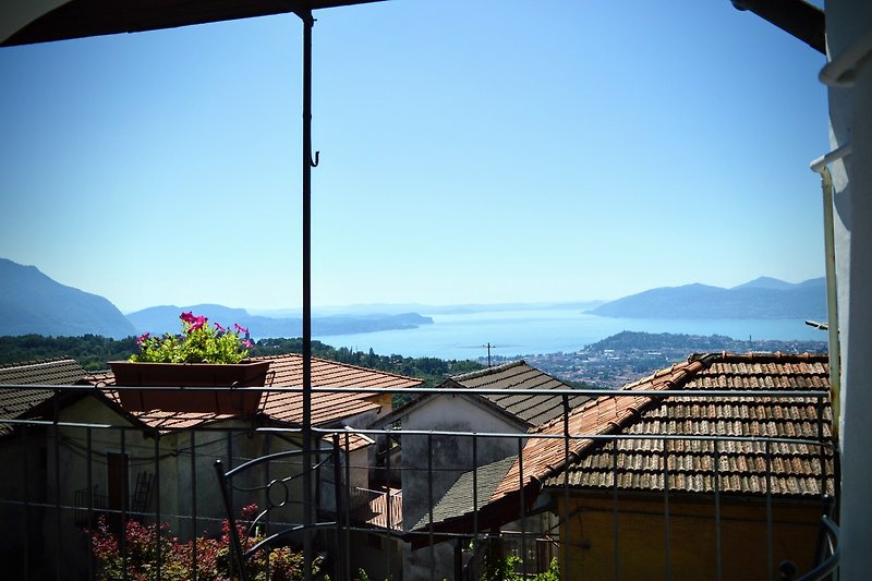 Blick auf Berge, Natur und Haus mit Balkon.