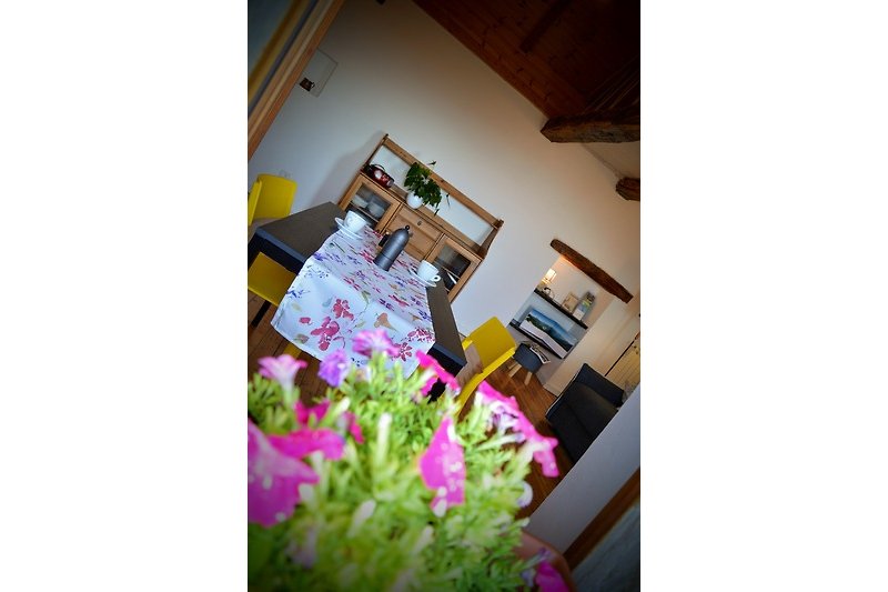 Elegante Tischdekoration mit lila Blumen und Holzmöbeln.