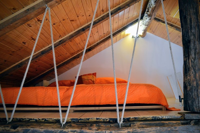 Ampia stanza con travi in legno e soffitto a vista.