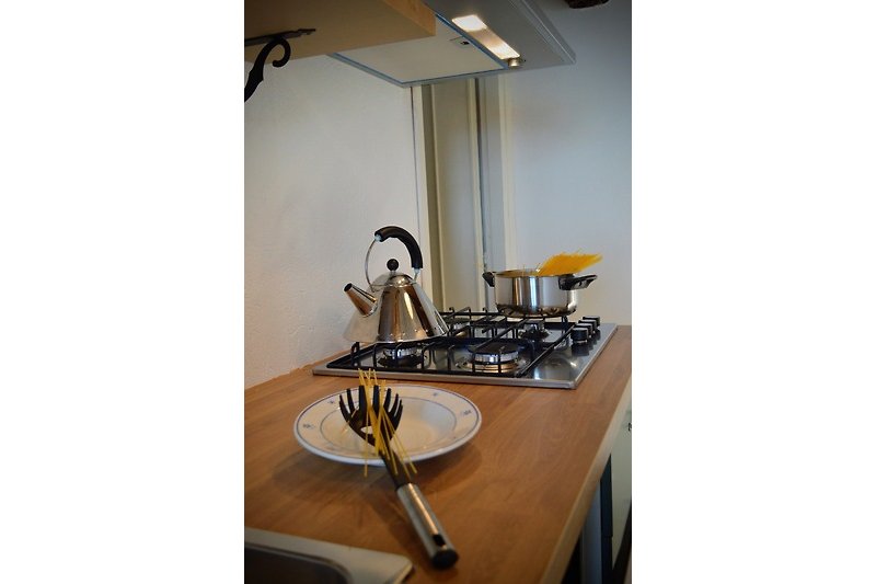 Cucina moderna con piano cottura a gas e utensili da cucina.