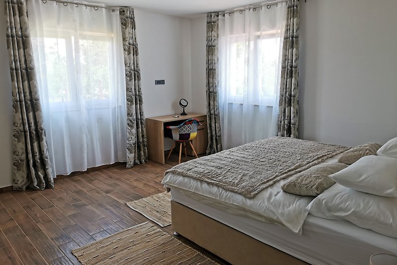 Elegantna spavaća soba s udobnim krevetom i lijepim dekoracijama.