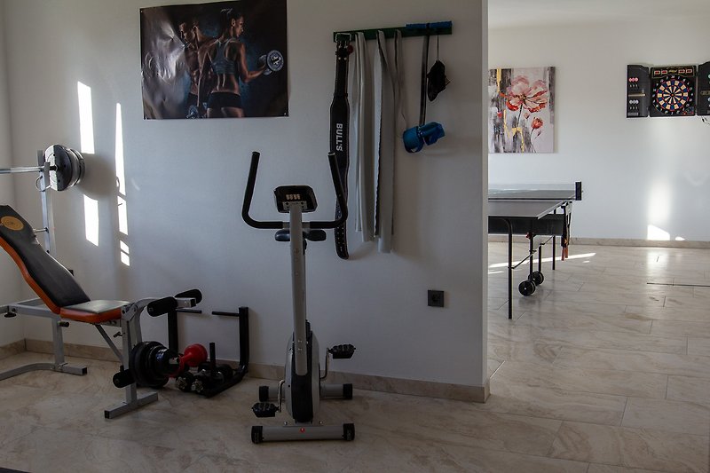 Udobna soba za vježbanje sa sportskim rekvizitima.