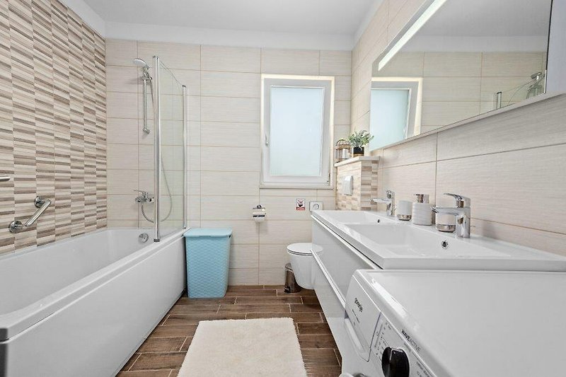 Elegantes Badezimmer mit modernen Armaturen und Glasdusche.