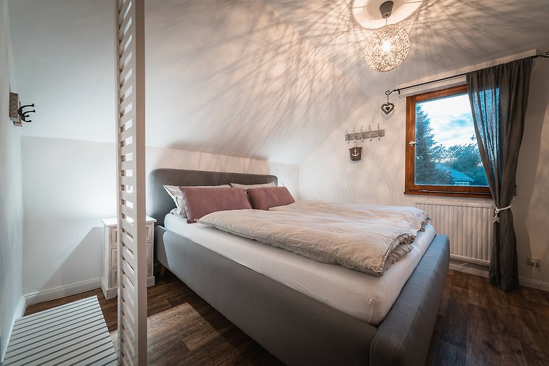 Elegantes Schlafzimmer mit bequemem Bett, stilvoller Beleuchtung und Dekoration.