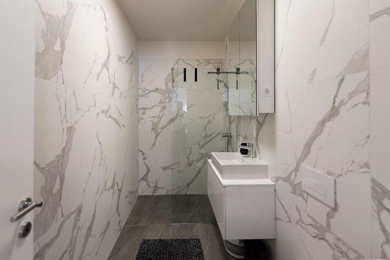 Badezimmer mit modernem Design, Glaswaschbecken und Kunst.