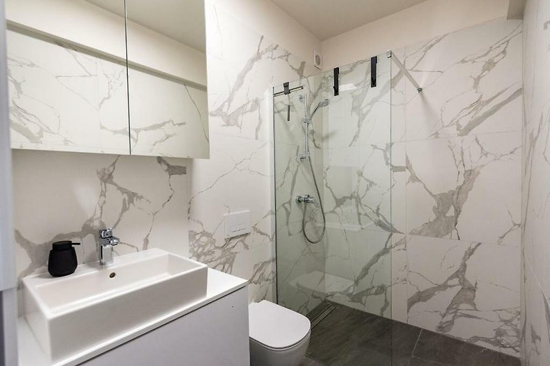 Badezimmer mit modernem Design, Glaswaschbecken und Kunst.