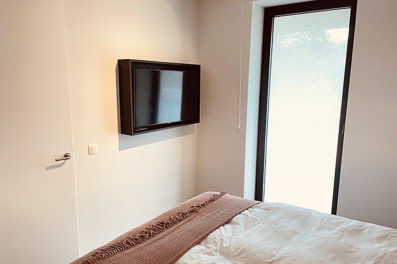 Schlafzimmer mit Digitales Fernsehen und grosse Fenster
