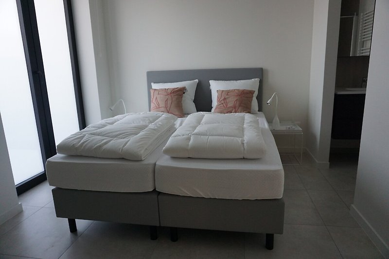 Modernes Schlafzimmer mit bequemem Bett, stilvollem Design und Holzmöbeln.