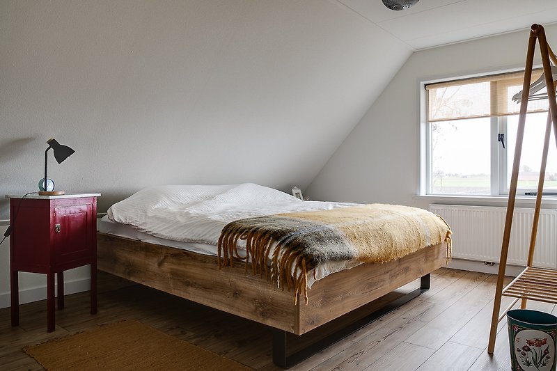 Stijlvolle slaapkamer met houten meubels en comfortabel bed.