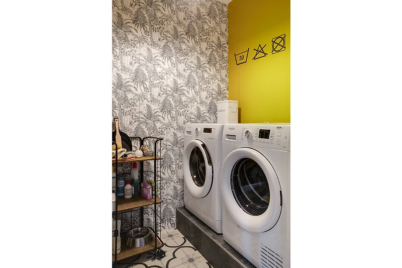 Moderne wasruimte met gele accenten en handige apparaten.