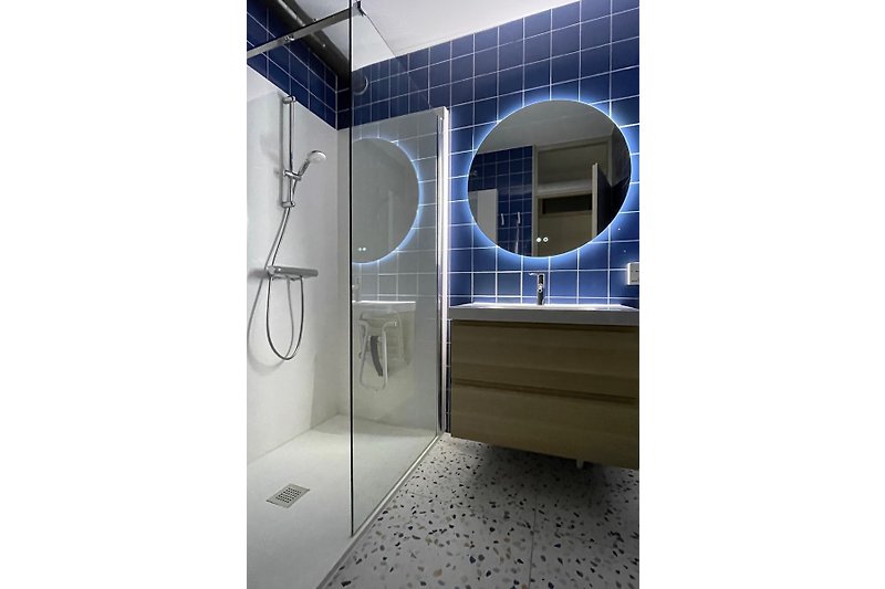 Badezimmer mit Dusche und Badezimmerschrank mit reichlich Stauraum