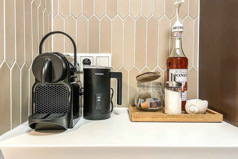 Kaffee-Ecke mit Nespresso-Kaffeemaschine und Milchaufschäumer.