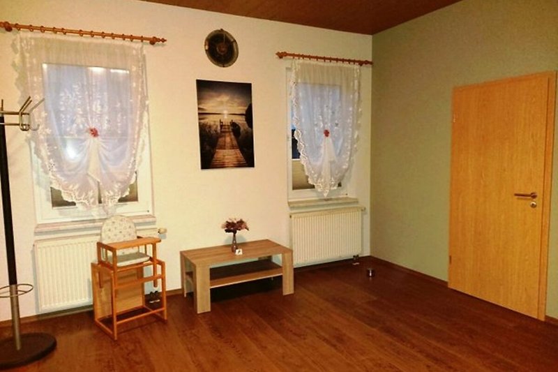 Schlafzimmer 2 mit Holzmöbeln, Gagefenster und Vorhängen. Gemütliche Einrichtung.
