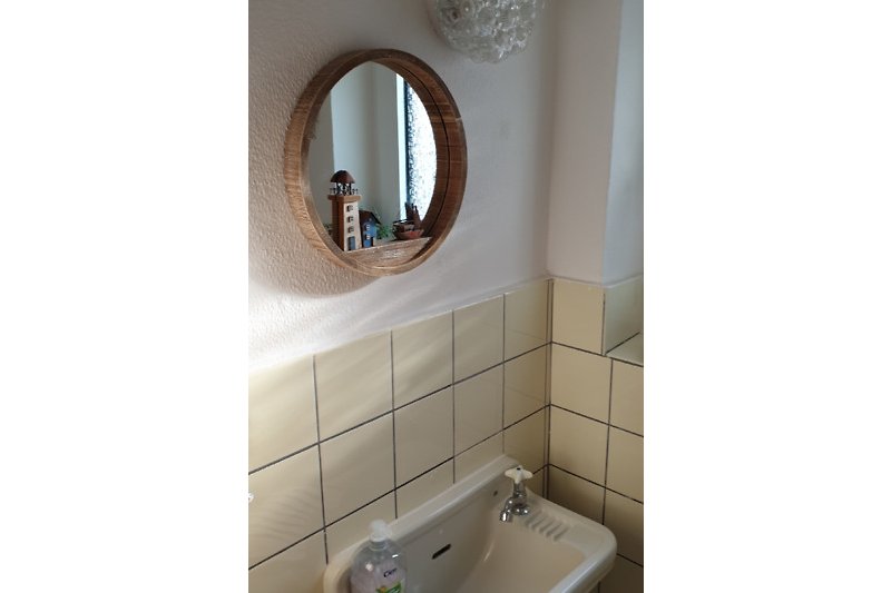 Gäste - WC mit maritimen  Spiegel, Waschbecken und Armatur.