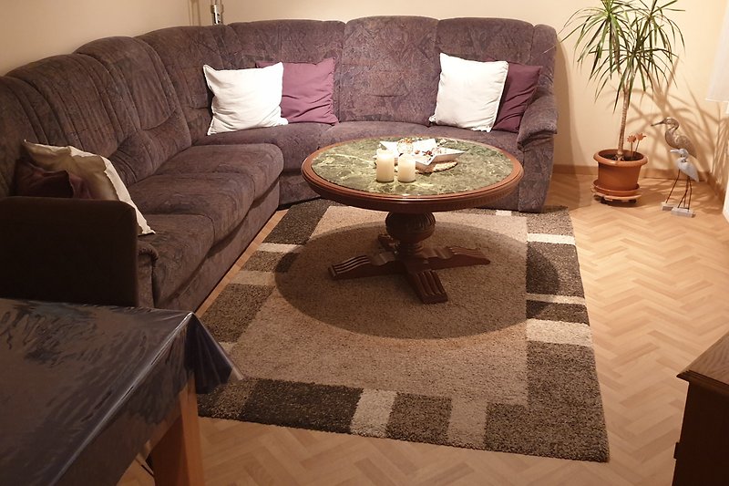 Wohnzimmer mit Holzmöbeln, Pflanzen und gemütlicher Einrichtung.