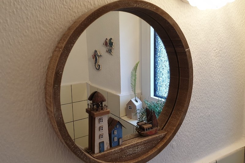 Spiegel, Pflanze, Holz - stilvolles Interieur mit natürlichen Elementen.