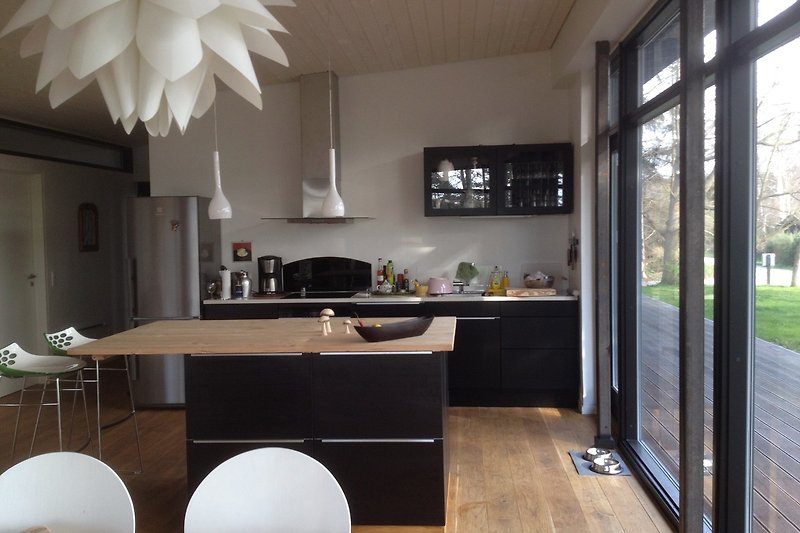Küche mit Holzmöbeln, Fenster, Blume und Tisch. Gemütliche Atmosphäre.