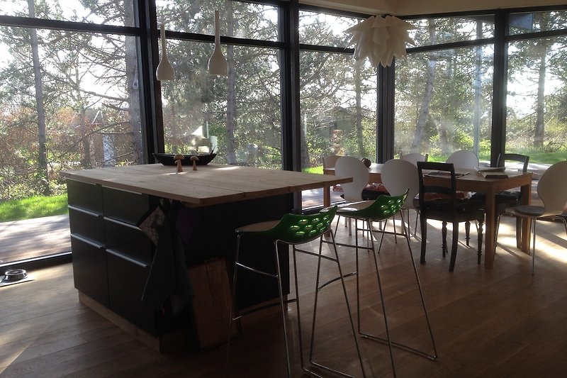 Geräumiges Wohnzimmer mit Holzmöbeln, Tisch, Stuhl und Pflanze.