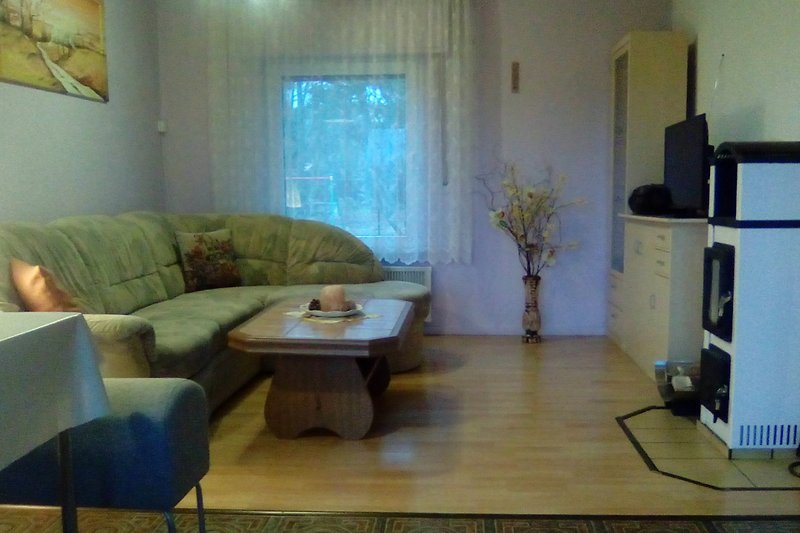 Wohnzimmer mit bequemer Couch und Esstischen