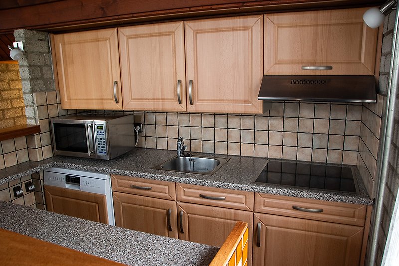 Moderne Küche mit Holzakzenten, Granitarbeitsplatte und Edelstahlgeräten.