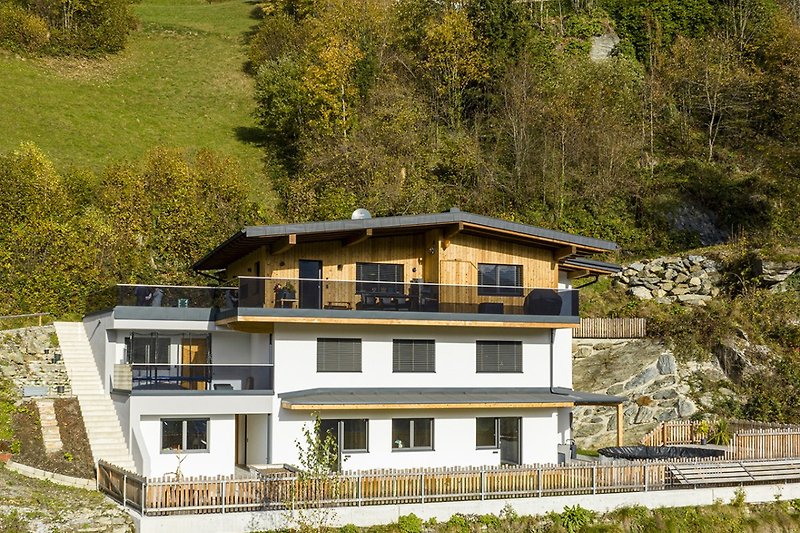 Ferienhaus mit grüner Landschaft und moderner Architektur.