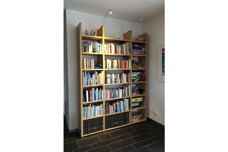 Bücherregal mit Holz und Sammlung von Büchern und Spiele.