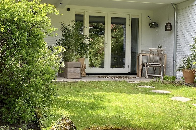 Ein charmantes Haus mit blühendem Garten und gemütlicher Veranda.