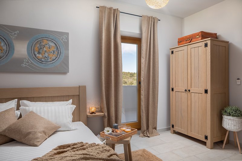 Stilvolles Schlafzimmer mit Holzmöbeln, gemütlichem Bett und Fensterblick.