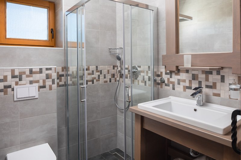 Modernes Badezimmer mit stilvoller Einrichtung und Glaswaschbecken.