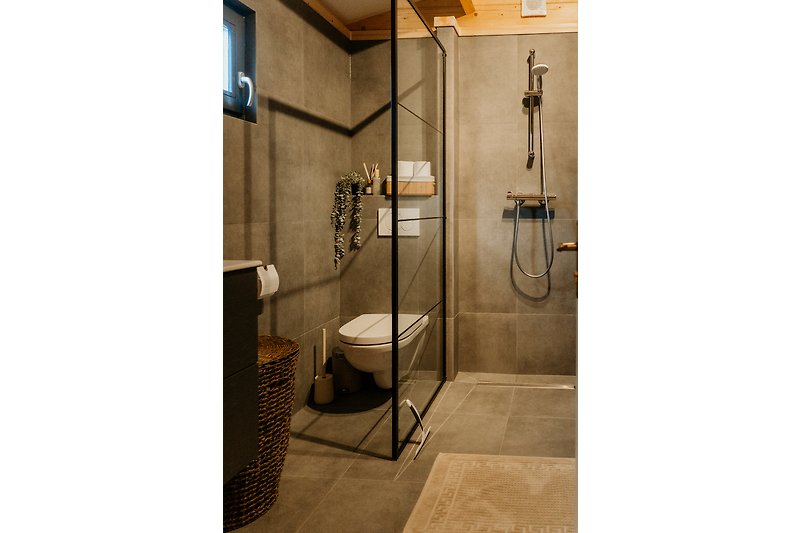 Moderne Dusche mit Glaswand und Metallgriff.