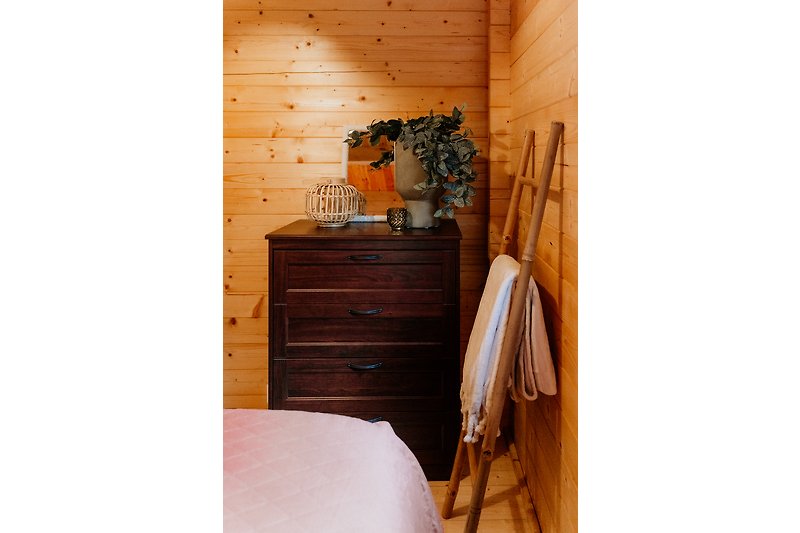 Holzhaus mit stilvollen Möbeln, Blumentopf und Lampe. Gemütliche Atmosphäre.