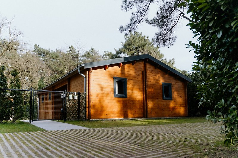 Charmantes Holzhaus mit grünem Garten und rustikaler Fassade.