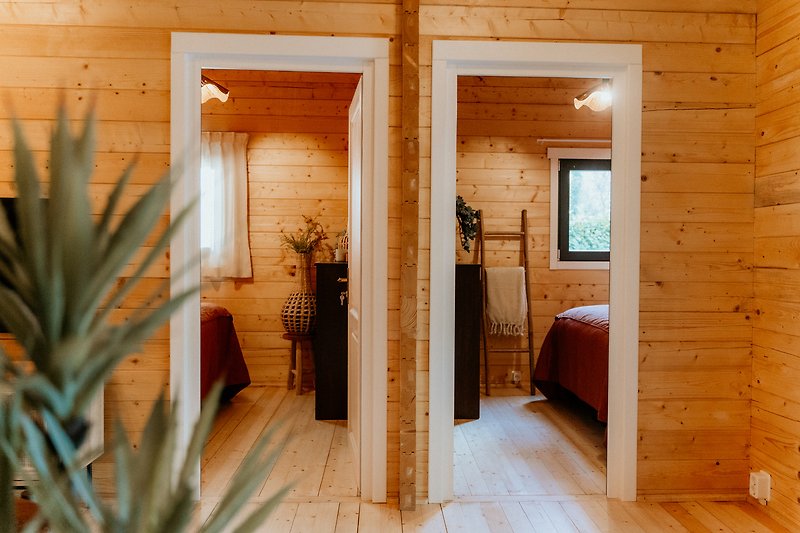 Holzhaus mit Blumen, Fenster, Tür und gemütlicher Einrichtung. Gemütliche Atmosphäre.