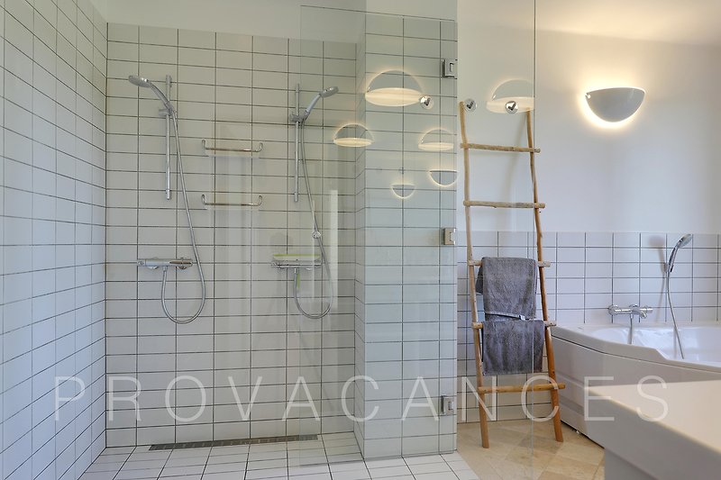 Modernes Badezimmer mit Dusche, Glas und Fliesen.