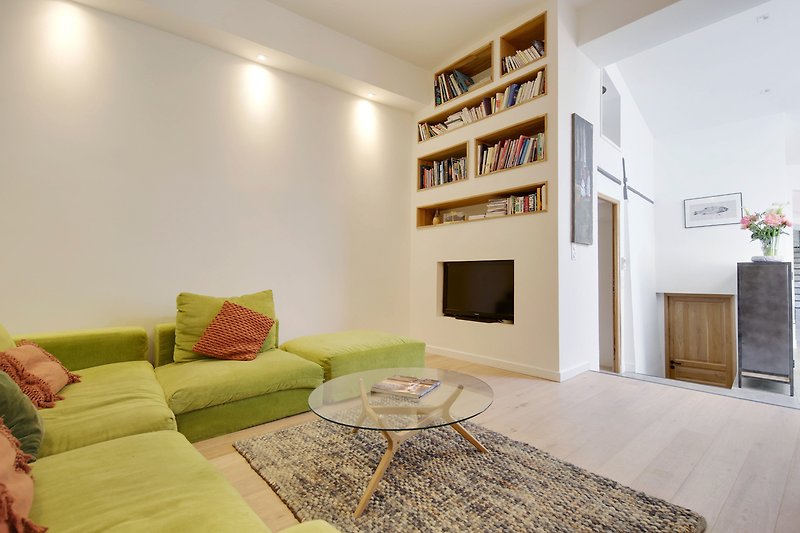 Wohnzimmer mit bequemer Couch, Holztisch und stilvollem Regal.