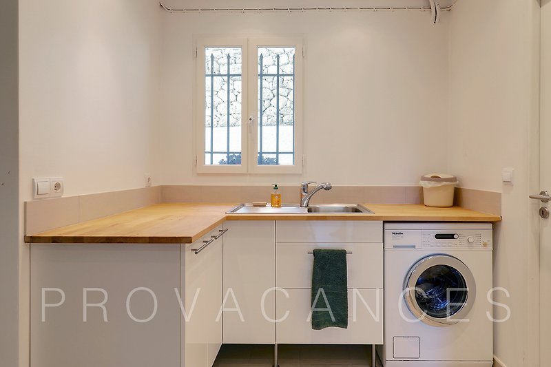 Moderne Küche mit Holzakzenten, Fenster und Waschmaschine.